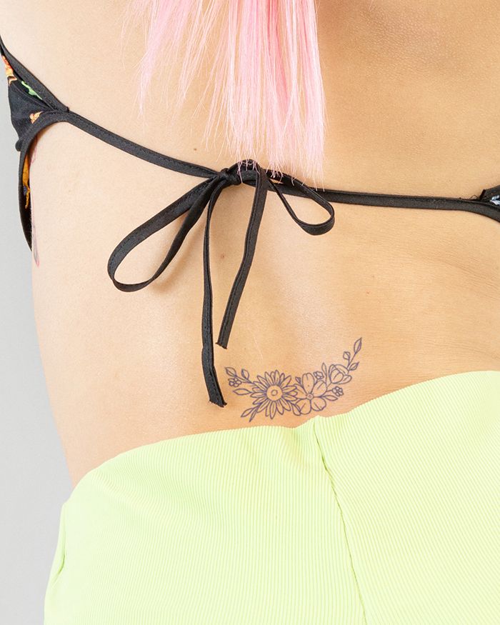 Nežna cvetlična tetovaža za spodnji del hrbta za ženske