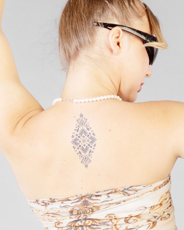 Prefinjena plemenska tetovaža na hrbtu za ženske