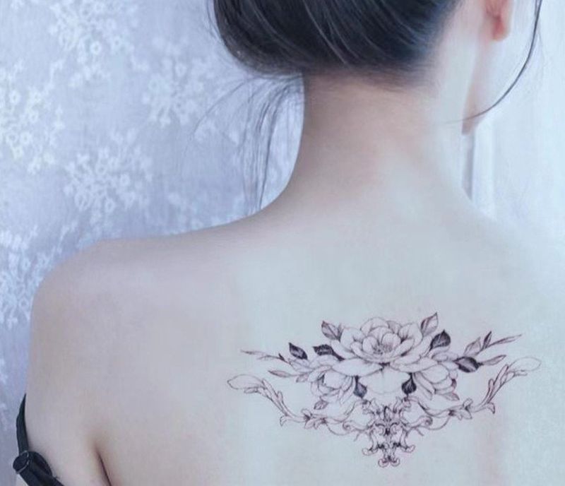 Nežna cvetlična tetovaža na hrbtu za ženske