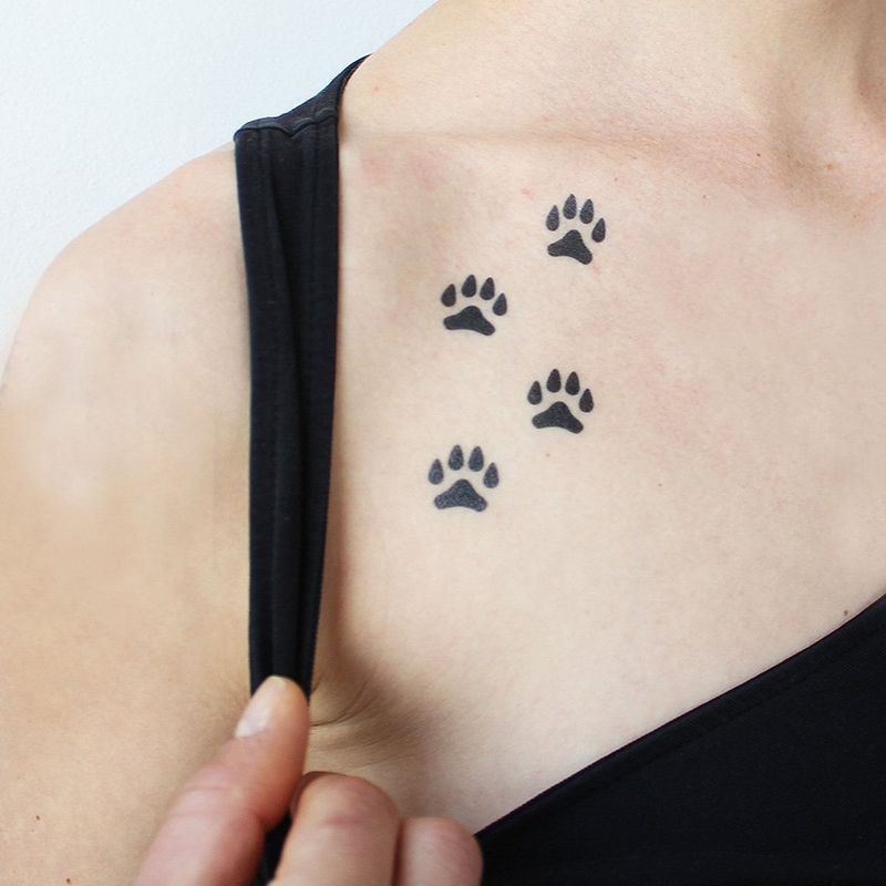 Quatre empreintes de pattes pour les meilleurs tatouages ​​​​de la clavicule pour les femmes
