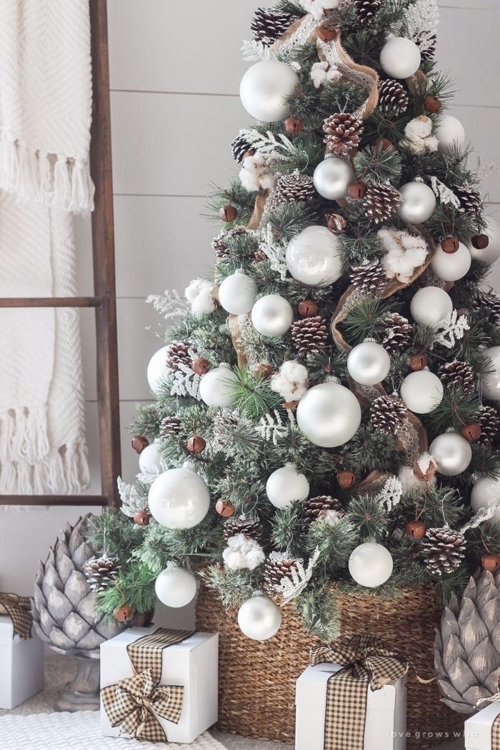 Arbre de Noël rustique avec des pommes de pin et des décorations blanches