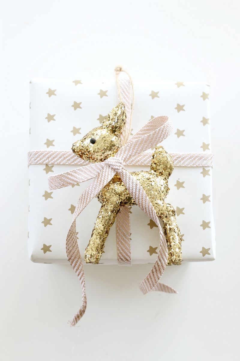 Emballage cadeau élégant blanc, rose et or avec jouet de renne doré