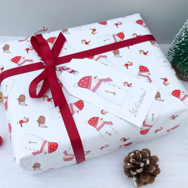 Joli papier cadeau de Noël blanc et rouge avec bonhomme de neige