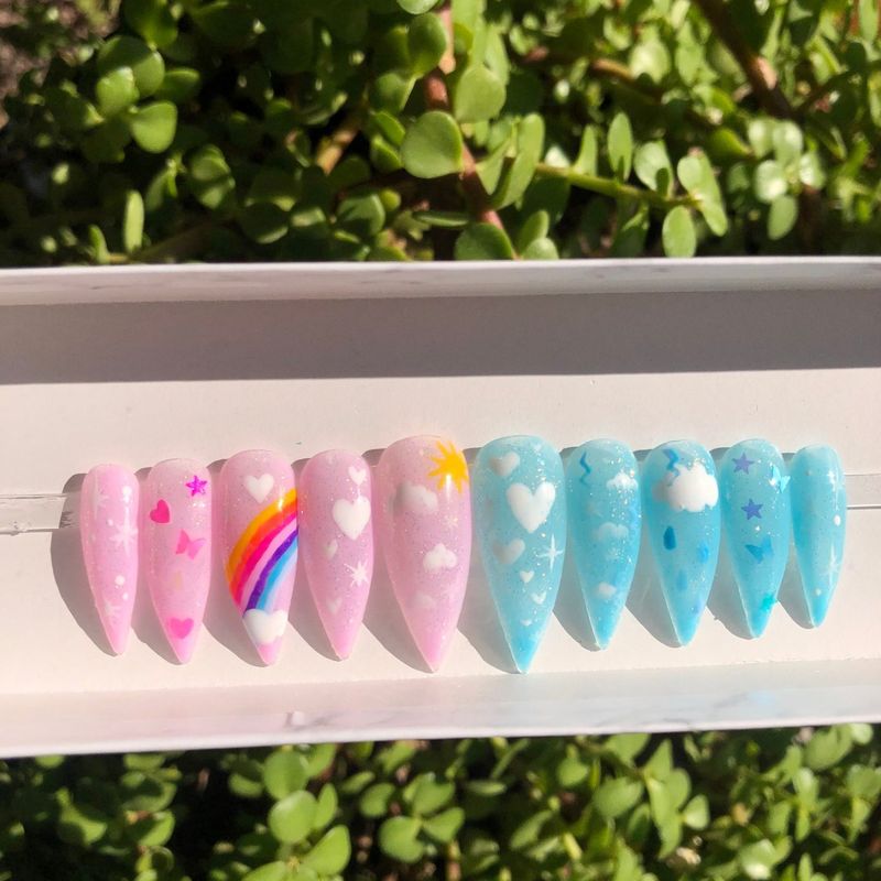 Søt rosa og blå trykk på negler i stilettoform med nail art
