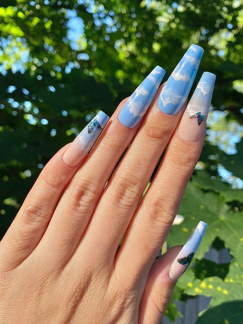 Svetlo modri oblački nohti z umetniškimi nohti z metuljčki v obliki akrilne krste