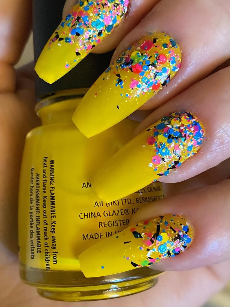 Žuti nokti prekriveni šarenim krupnim svjetlucavima