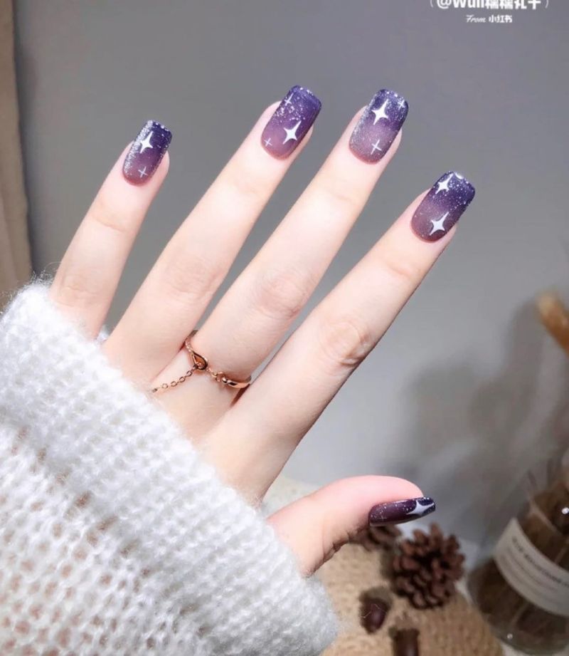 Темно-фіолетові нігті з зірковим нейл-артом