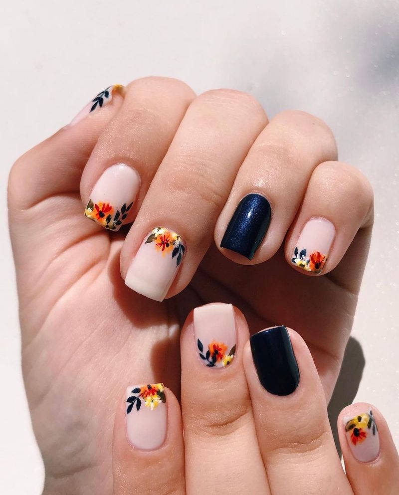 Ongles carrés courts mignons avec nail art bleu foncé et fleur