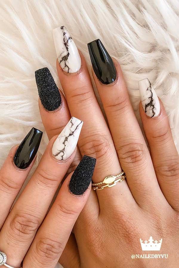 Ongles noirs à paillettes avec nail art en marbre blanc
